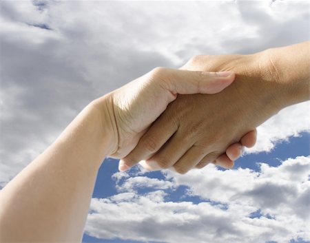 simsearch:640-03262464,k - A pair of hands holding or shaking each other against a cloudy background. Concept: Business deal done. Stock Photo - Budget Royalty-Free & Subscription, Code: 400-03912423