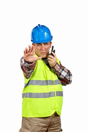 Construction worker with green safety vest worker talking with a walkie talkie and orders to stop. Hand on focus Stock Photo - Budget Royalty-Free & Subscription, Code: 400-03912901