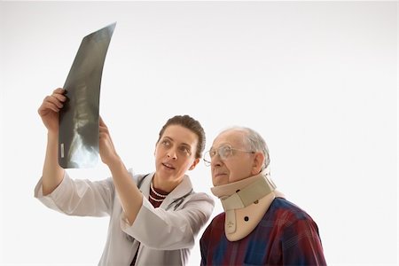 Mid-adult Caucasian female doctor showing x-ray to elderly Caucasian male in neck brace. Stock Photo - Budget Royalty-Free & Subscription, Code: 400-03924224