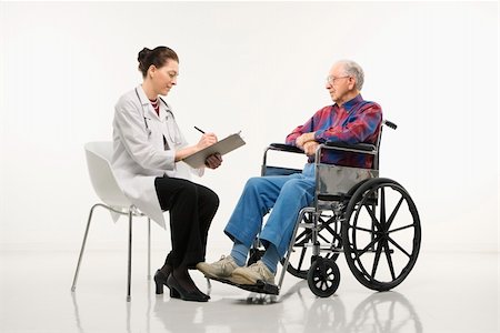 Mid-adult Caucasian female doctor taking notes with an elderly Caucasian male in wheelchair to her side. Stock Photo - Budget Royalty-Free & Subscription, Code: 400-03924227