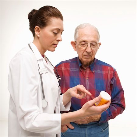 Mid-adult Caucasian female doctor pointing at prescription bottle as elderly Caucasian male looks at bottle. Stock Photo - Budget Royalty-Free & Subscription, Code: 400-03924229