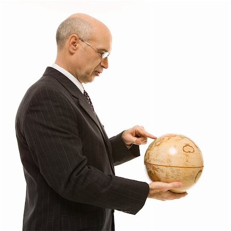 Caucasian middle-aged businessman holding globe and pointing standing in front of white background. Stock Photo - Budget Royalty-Free & Subscription, Code: 400-03924335