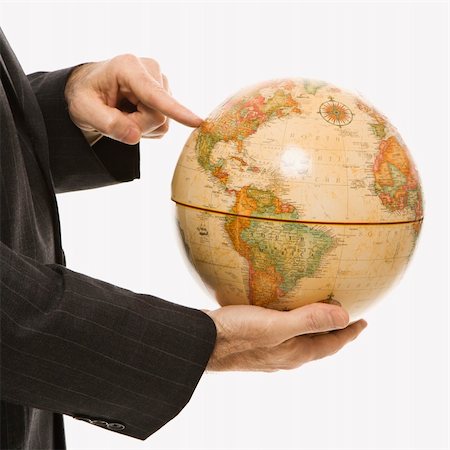 Caucasian middle-aged businessman holding globe and pointing standing in front of white background. Stock Photo - Budget Royalty-Free & Subscription, Code: 400-03924336