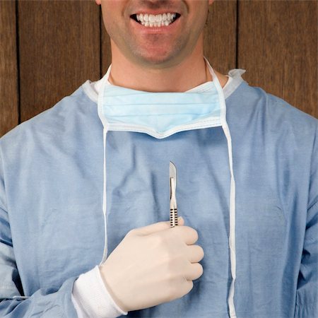 simsearch:400-04450069,k - Mid-adult Caucasian male surgeon holding scalpel and smiling. Stock Photo - Budget Royalty-Free & Subscription, Code: 400-03924528