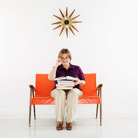 simsearch:400-04450069,k - Caucasian middle aged woman sitting holding stack of books. Stock Photo - Budget Royalty-Free & Subscription, Code: 400-03925638