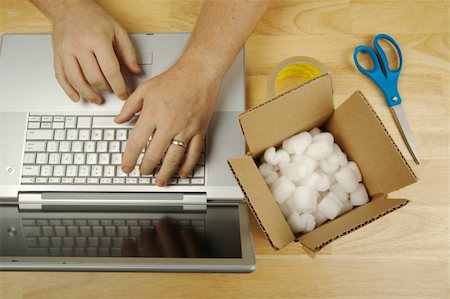 simsearch:695-05771662,k - Businessman Works on Laptop with sales item and packaging materials at his side. Stock Photo - Budget Royalty-Free & Subscription, Code: 400-03928448