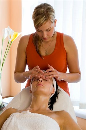 simsearch:400-03950910,k - A beautiful dark haired woman recieves a facial treatment from a young blonde beautician Photographie de stock - Aubaine LD & Abonnement, Code: 400-03929437