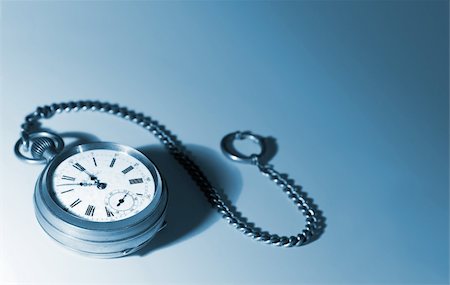 simsearch:600-01551669,k - Old silver pocket watches on a chain; on a white background; focused on dial; picture tinted blue Stock Photo - Budget Royalty-Free & Subscription, Code: 400-03920219