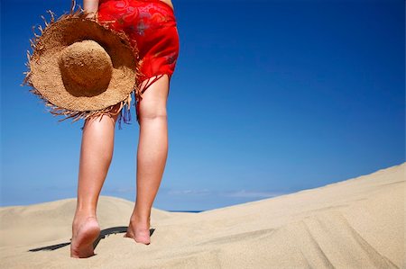 simsearch:400-03950469,k - Woman walking across a sandy beach with a satraw hat Stock Photo - Budget Royalty-Free & Subscription, Code: 400-03920268