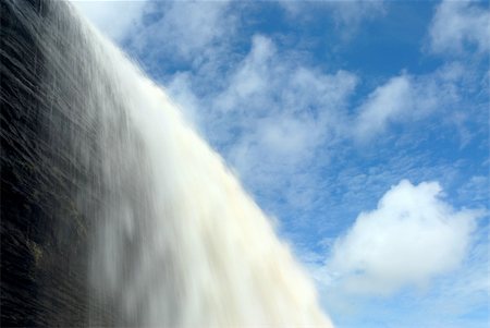 pictures of south america tropical waterfalls - Water falls over a cliff surrounded by a blue sky with clouds. Stock Photo - Budget Royalty-Free & Subscription, Code: 400-03938510