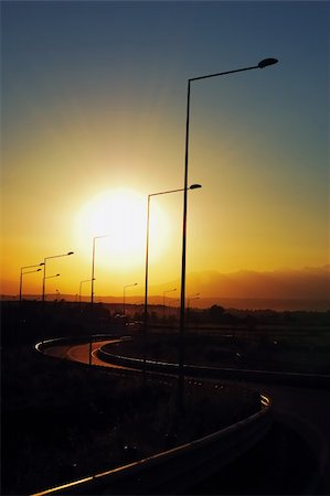 ramps on the road - Highway overpass in backlight at sunset Foto de stock - Super Valor sin royalties y Suscripción, Código: 400-03939042