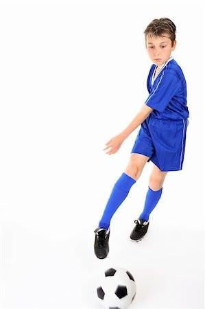 Child kicking or manoeuvring a soccer ball.  Motion to ball and kicking foot. Stock Photo - Budget Royalty-Free & Subscription, Code: 400-03931814