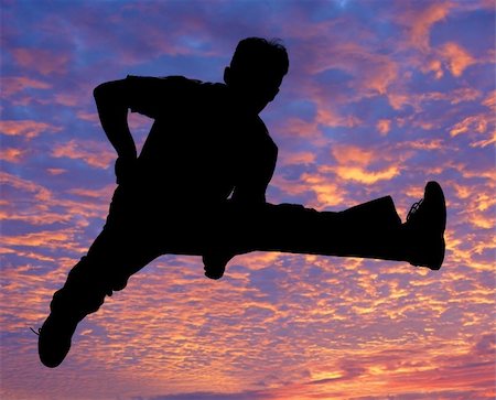 Boy jumping high in the air against the sunset Stock Photo - Budget Royalty-Free & Subscription, Code: 400-03944609