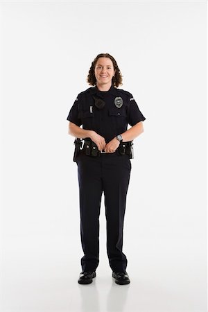 female police officer happy - Portrait of mid adult Caucasian policewoman standing with hands on gun holster looking at viewer smiling. Photographie de stock - Aubaine LD & Abonnement, Code: 400-03940742