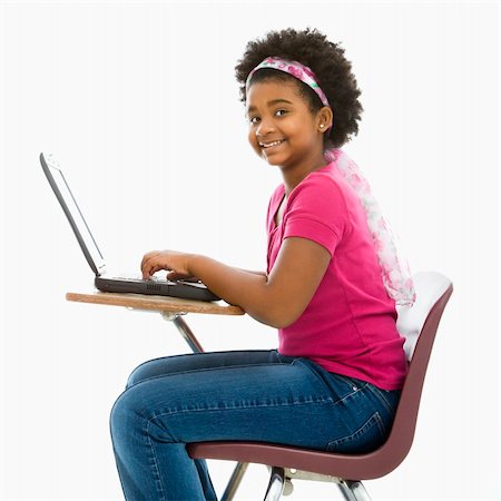 simsearch:400-05012508,k - African American girl sitting in school desk typing on laptop computer smiling at viewer. Foto de stock - Super Valor sin royalties y Suscripción, Código: 400-03940965