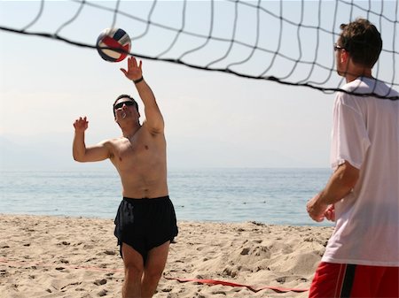 simsearch:632-01155154,k - Young men playing volleyball on the beach Stock Photo - Budget Royalty-Free & Subscription, Code: 400-03941431