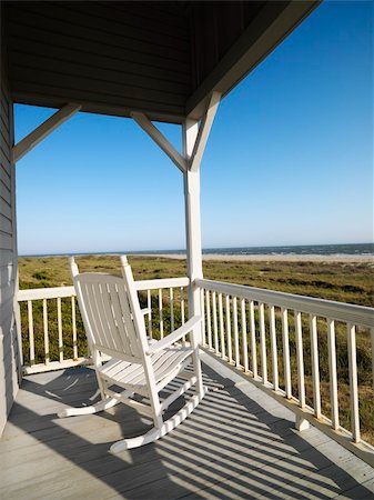 simsearch:649-02054287,k - Rocking chair on porch with railing overlooking beach at Bald Head Island, North Carolina. Stock Photo - Budget Royalty-Free & Subscription, Code: 400-03943957