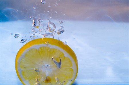 Slice of lemon splashing Stock Photo - Budget Royalty-Free & Subscription, Code: 400-03956927