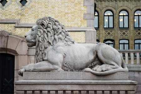 A lion statue sits majesticaly on it's pedestal. Photographie de stock - Aubaine LD & Abonnement, Code: 400-03951187