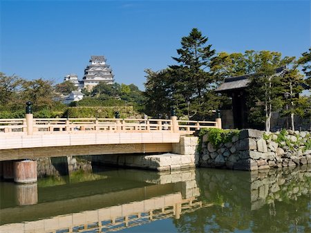 simsearch:400-06640469,k - Entrance to Himeji Castle grounds surrounded by a moat with main gate and bridge crossing in the foreground and Himeji Castle with clear blue sky in the background Stock Photo - Budget Royalty-Free & Subscription, Code: 400-03969502