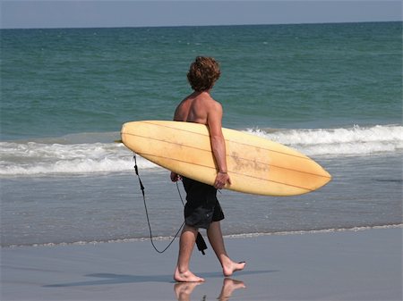 simsearch:400-03944633,k - a young man walking along the beach with his surfboard Stock Photo - Budget Royalty-Free & Subscription, Code: 400-03969791