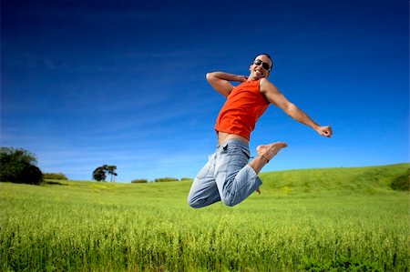 simsearch:400-03934248,k - Man jumping on a green meadow with a beautiful cloudy sky Stock Photo - Budget Royalty-Free & Subscription, Code: 400-03975684