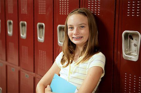 simsearch:614-06973669,k - An adorable teen girl with braces and freckles standing in front of her locker. Stock Photo - Budget Royalty-Free & Subscription, Code: 400-03970434