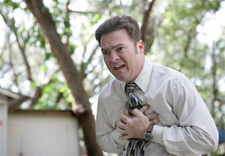 A forty year old businessman outdoors experiencing chest pain. Stock Photo - Budget Royalty-Free & Subscription, Code: 400-03972278