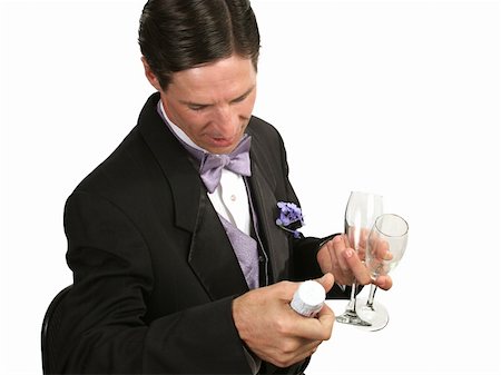 simsearch:846-05646372,k - A handsome man in a tuxedo with a champagne  bottle and glasses, checking the vintage of the champagne. Photographie de stock - Aubaine LD & Abonnement, Code: 400-03972382