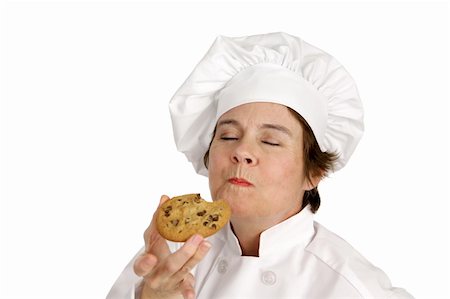 simsearch:614-06537664,k - Chef enjoying a delicious chocolate chip cookie she just baked.  Isolated on white. Stock Photo - Budget Royalty-Free & Subscription, Code: 400-03972773