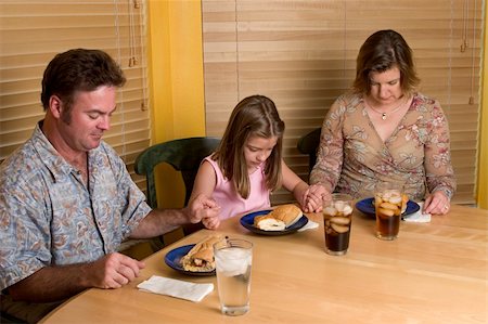 Family holding hands and saying grace at the table. Stock Photo - Budget Royalty-Free & Subscription, Code: 400-03973791