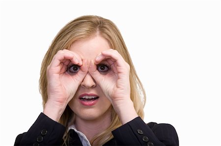 Attractive blonde woman in professional business suit standing on white looking through hands curved over eyes in the shape of eyeglasses or binoculars Stock Photo - Budget Royalty-Free & Subscription, Code: 400-03996651