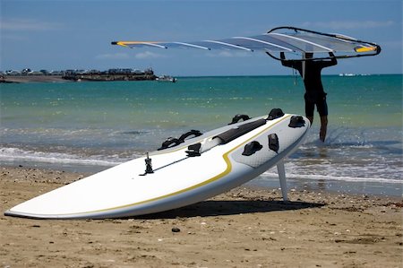 simsearch:400-03992760,k - Male windsurfer carrying a sail into the water, surf board at the water edge close-up. Stock Photo - Budget Royalty-Free & Subscription, Code: 400-03992761