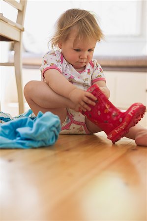 Girl Putting on Rubber Boots Foto de stock - Sin royalties Premium, Código: 600-04525180