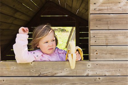 Young Girl Eating Banana while Looking out of Barn Window, Sweden Stock Photo - Premium Royalty-Free, Code: 600-04926389