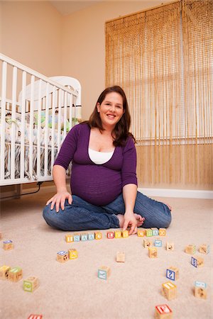 simplymui - Pregnant Woman with Building Blocks, Sitting on Floor next to Crib Foto de stock - Sin royalties Premium, Código: 600-04926437