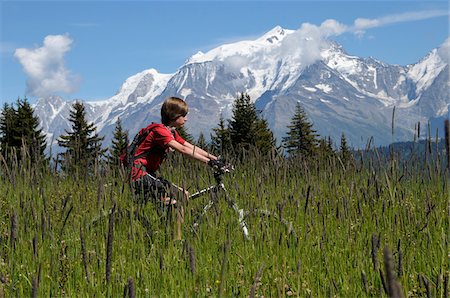 Boy Riding Bicycle in Mountains, Alps, France Stock Photo - Premium Royalty-Free, Code: 600-05524698