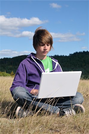 simsearch:600-05389108,k - Boy Sitting in Field using Laptop Computer, Blandas, Gard, France Foto de stock - Sin royalties Premium, Código: 600-05662602