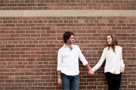 Portrait of Young Couple Standing in front of Brick Wall Foto de stock - Sin royalties Premium, Código: 600-05786144