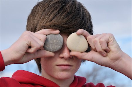 Teenage Boy holding Stones over Eyes, Sete, France Stock Photo - Premium Royalty-Free, Code: 600-05855274