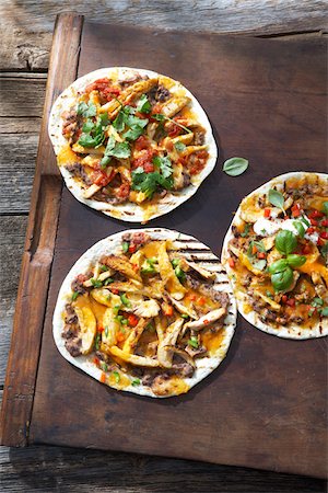 simsearch:600-06382994,k - Grilled Mini Pizzas with Chicken, Avocado, Basil, Cilantro, Refried Beans, Hot Peppers and Salsa Stock Photo - Premium Royalty-Free, Code: 600-06038253