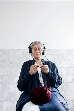 Woman Knitting and Listening to Headphones Stock Photo - Premium Royalty-Free, Code: 600-06144860
