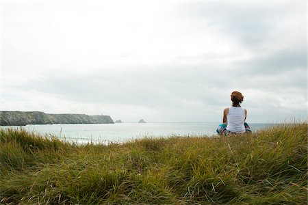 Woman Sitting and Looking into the Distance at the Beach, Camaret-sur-Mer, Crozon Peninsula, Finistere, Brittany, France Stock Photo - Premium Royalty-Free, Code: 600-06382811