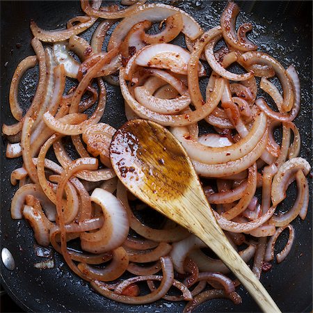 Overhead View of Frying Red Onions in Frying Pan and Wooden Spoon Stock Photo - Premium Royalty-Free, Code: 600-06397692