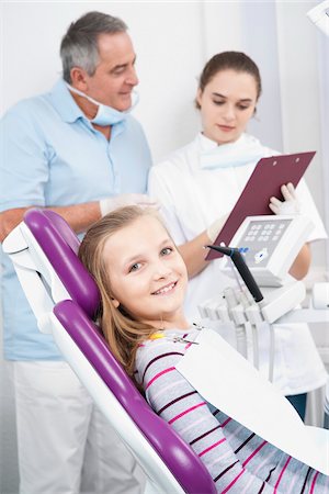 dental girls - Portrait of Girl at Dentist's Office with Dentist and Hygienist in background looking at Medical Chart, Germany Stock Photo - Premium Royalty-Free, Code: 600-06438932