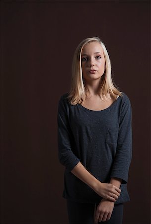 Portrait of Blond, Teenage Girl Looking at Camera, Studio Shot on Black Background Stock Photo - Premium Royalty-Free, Code: 600-06438952