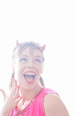 Portrait of Woman Wearing Devil Horns Making Faces Stock Photo - Premium Royalty-Free, Code: 600-06431366
