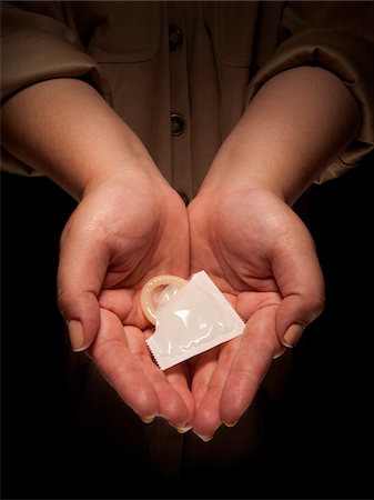 safe sex - Close-up of Woman's Hands holding Condom, Studio Shot Stock Photo - Premium Royalty-Free, Code: 600-06452119