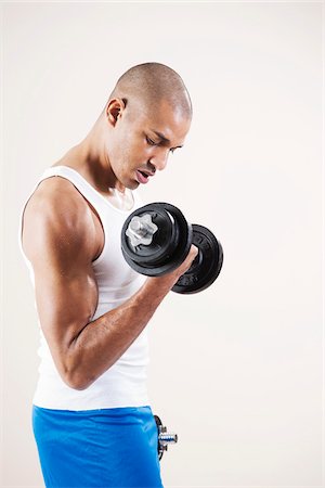 shaved head - Man Wearing Work Out Clothes and Lifting Weights in Studio with White Background Stock Photo - Premium Royalty-Free, Code: 600-06485938