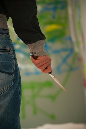 Close-up of Young Man Holding Knife with Graffiti in Background, Mannheim, Baden-Wurttemberg, Germany Stock Photo - Premium Royalty-Free, Code: 600-06486013